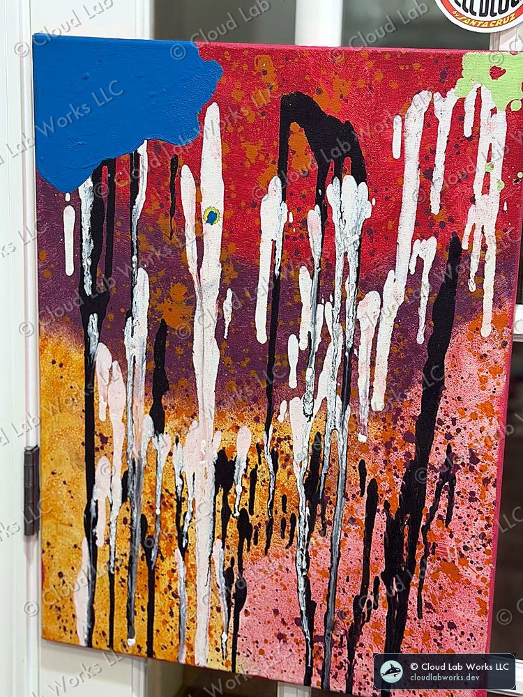 Acrylic pour on a wall: white and black drips running down a red and orange field with a blue corner